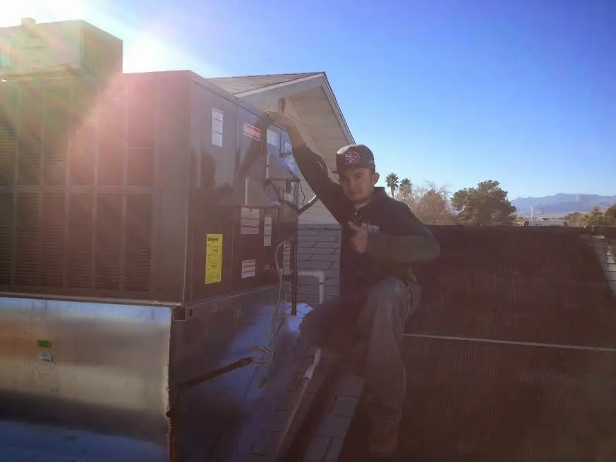 HVAC technician performing AC Tune-Up on a rooftop unit in Cordele